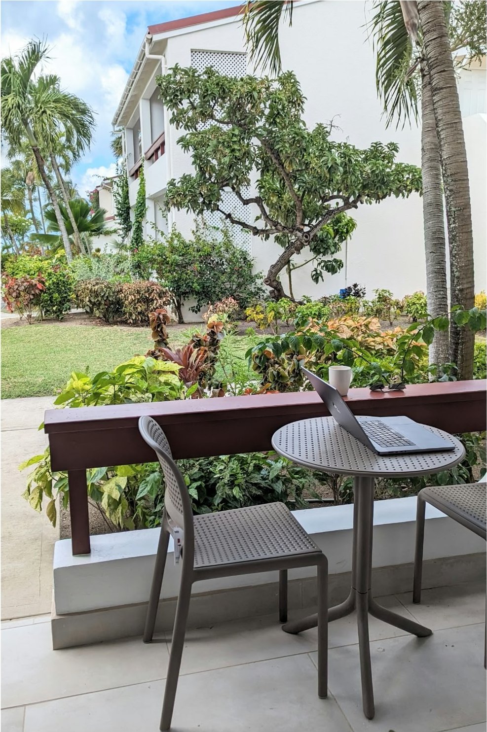 The patio table, laptop open before the beach